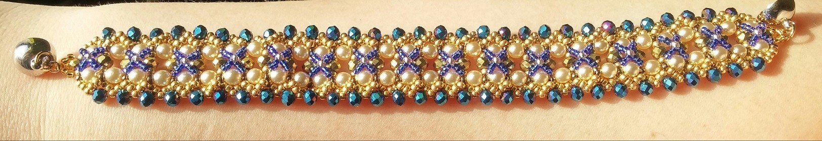 Bracciale dorato perle bianche e perle blu aperto